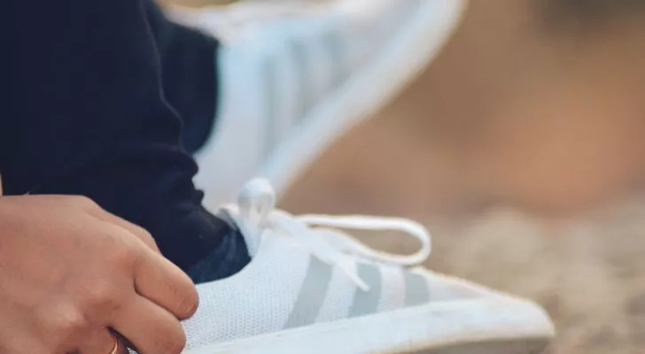 White Adidas sneakers with three gray stripes